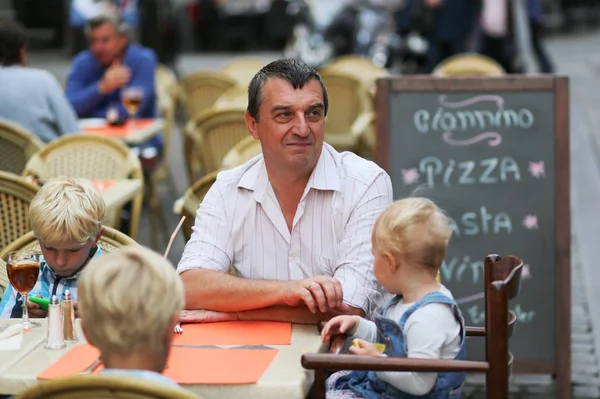 Padre con tres hijos divirtiéndose en la cafetería — Foto de Stock