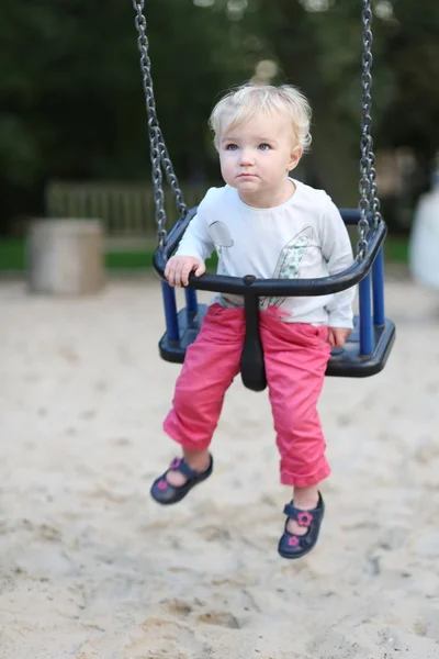 Meisje van de baby plezier op een schommel rit — Stockfoto