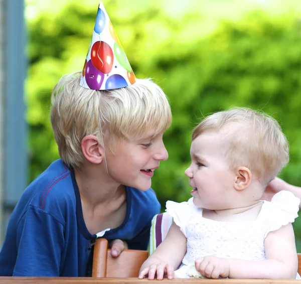 Boy celebrating first birthday of his sister — Stock Photo, Image