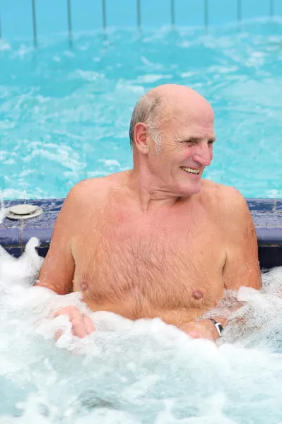 Homem se divertindo na piscina desfrutando jacuzzi — Fotografia de Stock