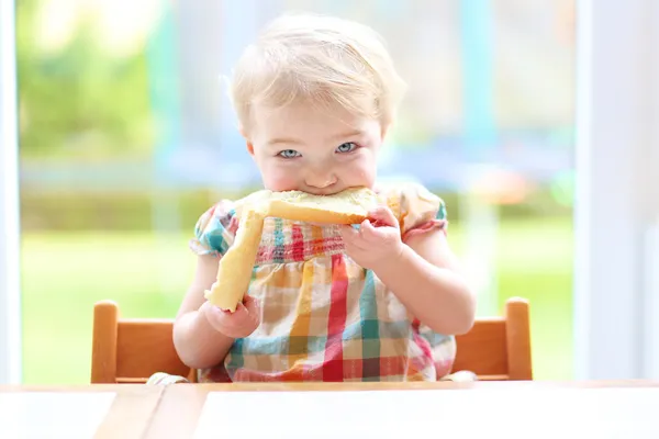 Girl eating tasty bread with butter — Stock Photo, Image
