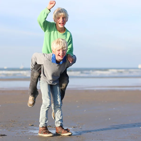 Broers plezier op het strand — Stockfoto