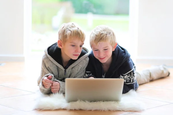 Brothers with notebook laying indoor — Stock Photo, Image