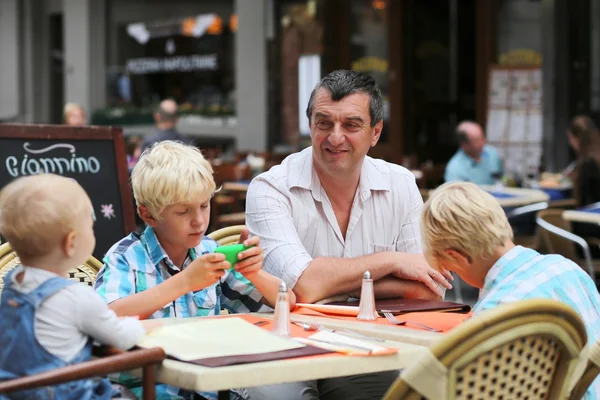 Padre con tre bambini che si divertono nel caffè — Foto Stock