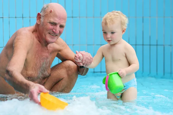 Farfar med barnbarn i poolen — Stockfoto