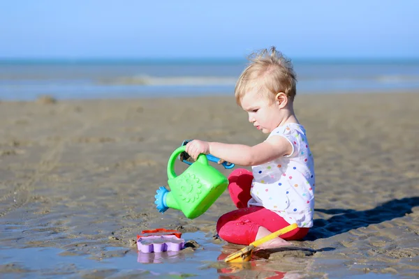 Flicka med vattenkanna på stranden — Stockfoto