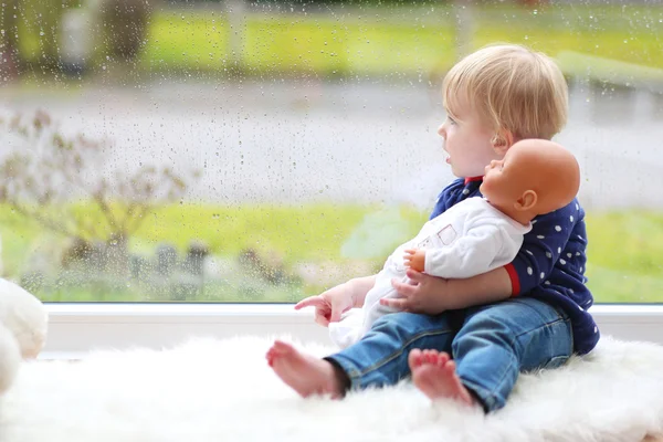 赤ちゃん人形と一緒に座っている女の子 — ストック写真