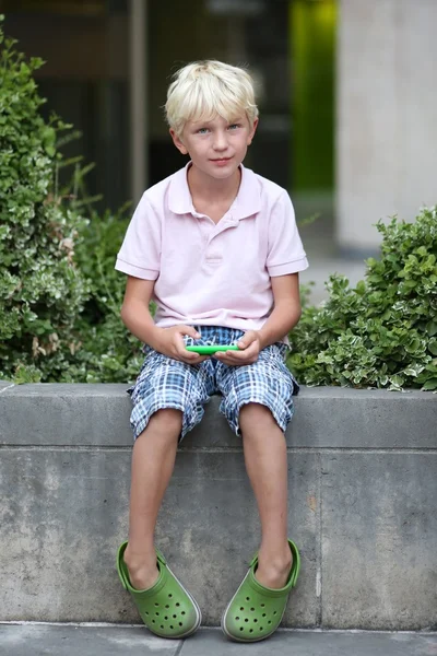 Boy playing gadget games on touchscreen smart phone — Stock Photo, Image