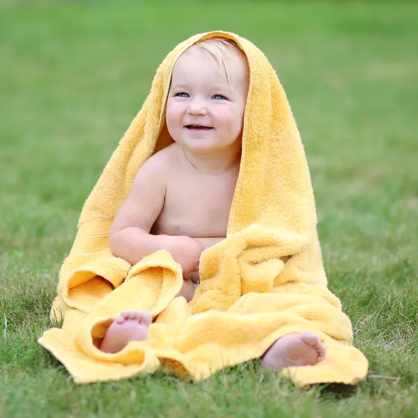 Baby having fun in yellow towel — Stock Photo, Image
