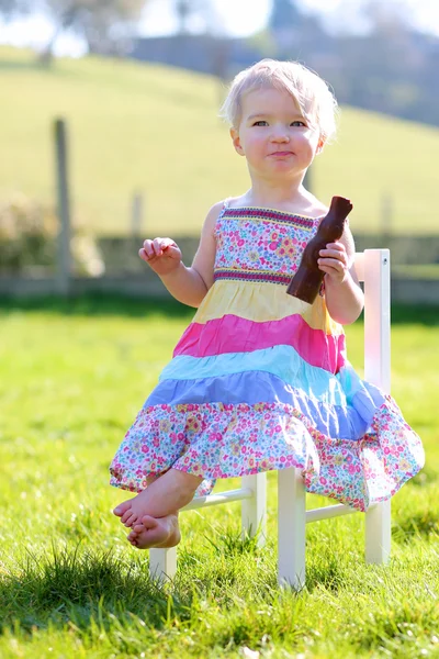 Dziewczynka jedzenie czekoladowy króliczek — Zdjęcie stockowe