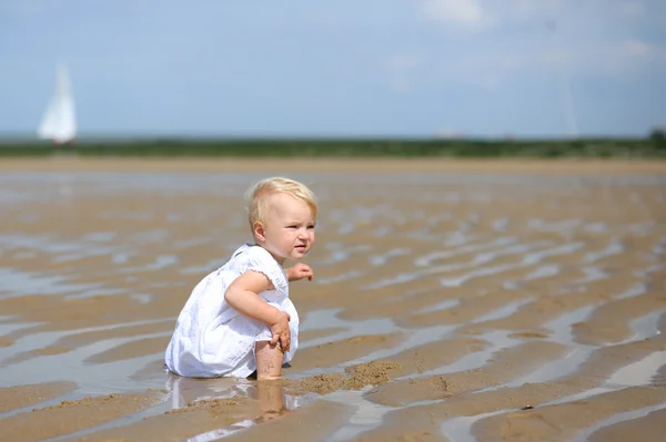 Baby girl sitting on a beach — Stock Photo, Image