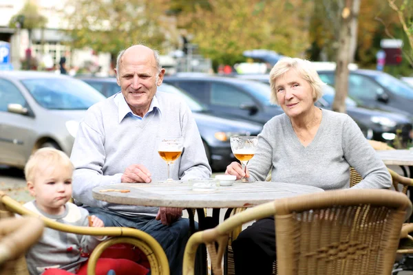 Para seniorów z ich wnuczka na tarasie — Zdjęcie stockowe