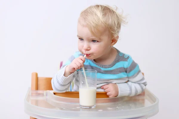 Дівчина п'є молоко зі склянки з соломою — стокове фото