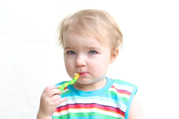 Girl eating porridge with spoon — Stock Photo, Image