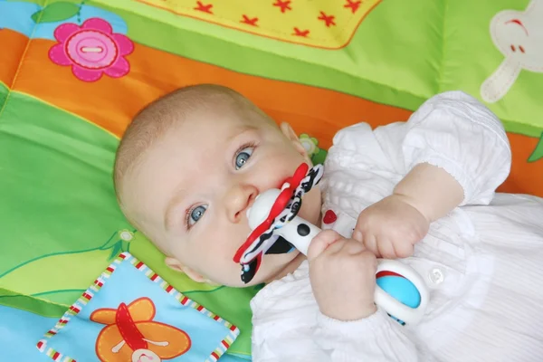 Baby Mädchen liegt auf Entwicklungsspielmatte — Stockfoto