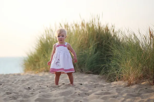 Meisje van de baby wandelen door de duinen — Stockfoto
