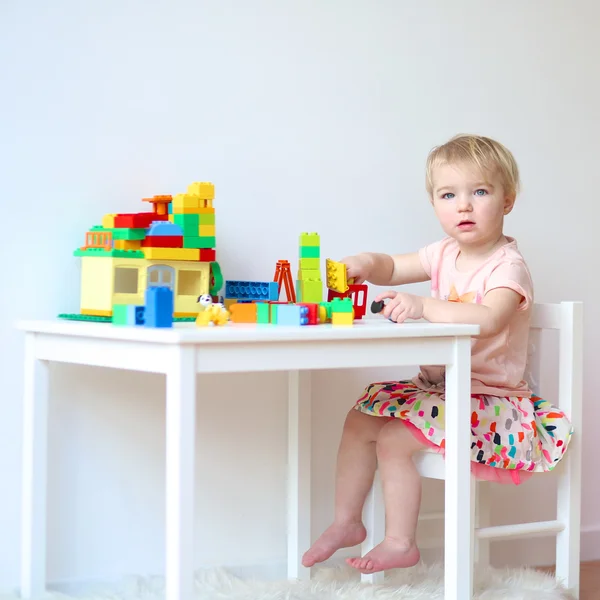 Girl building house from plastic blocks — Stock Photo, Image