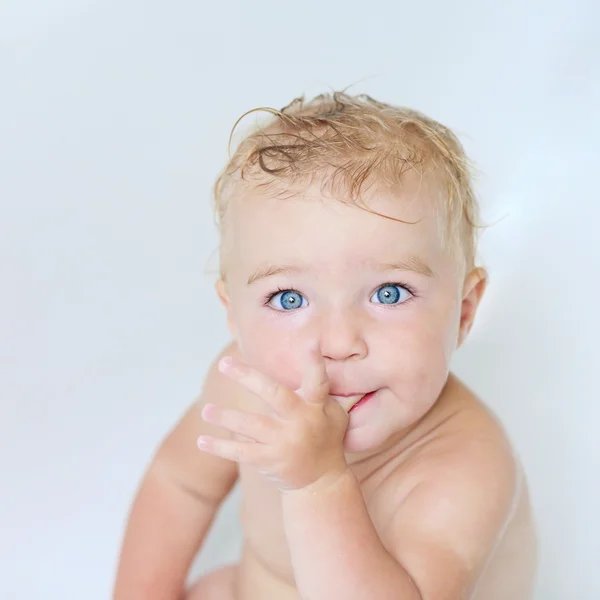 Baby girl in a bath sucking on her thumb — Stock Photo, Image