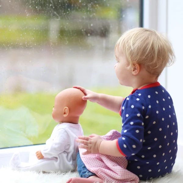 Fille assise avec poupée bébé — Photo