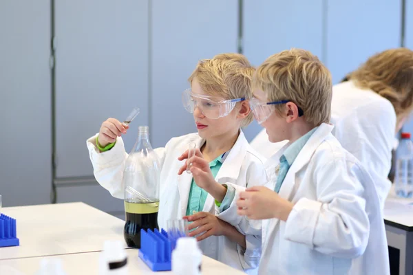 在化学实验室里做实验的学校男孩 — 图库照片