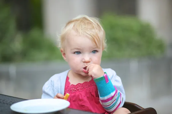 Bambino ragazza mangiare gustose patatine fritte — Foto Stock