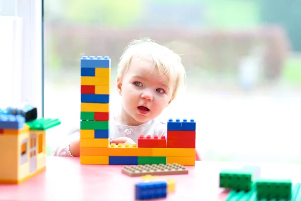 Girl building house from plastic blocks — Stock Photo, Image