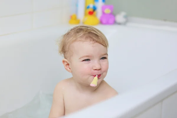 Ragazza lavarsi i denti con spazzolino da denti seduto nella vasca da bagno — Foto Stock