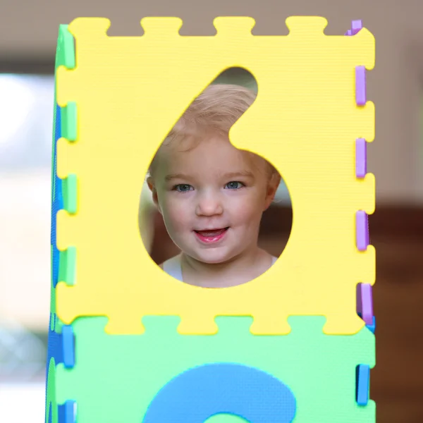 Girl playing hide and seek with colorful numbers puzzles — Stock Photo, Image