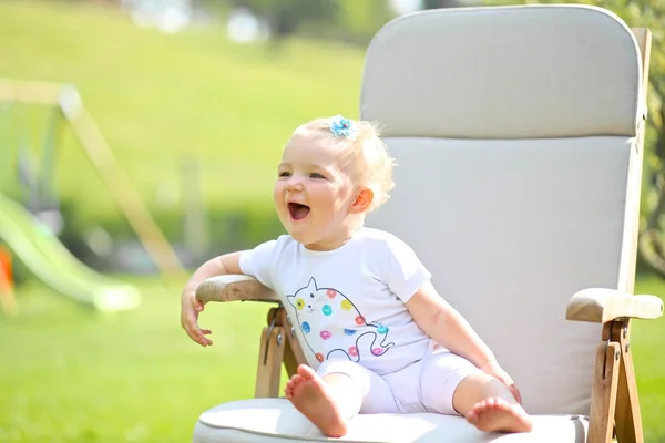 Bebê menina sentado em uma cadeira de teca de madeira — Fotografia de Stock