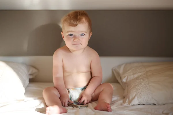 Bebé sentado en la cama de los padres justo después de despertar —  Fotos de Stock