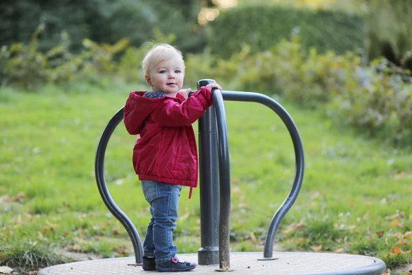 Baby girl riding on merry-go-round carousel — Stock Photo, Image