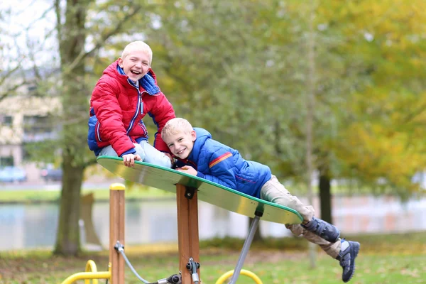 Twin brothers in the park at playground — Stock Photo, Image