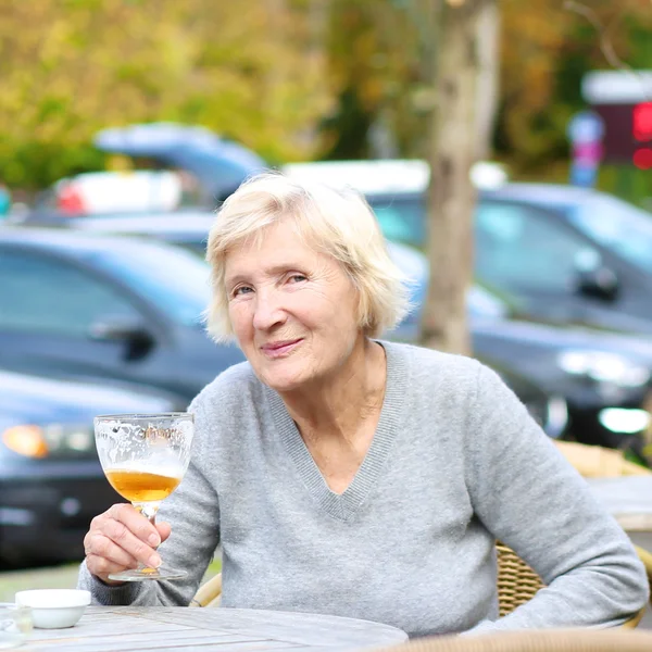 Frau im Café trinkt kaltes frisches Bier — Stockfoto