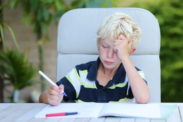 Garçon fatigué faisant des tâches de devoirs — Photo