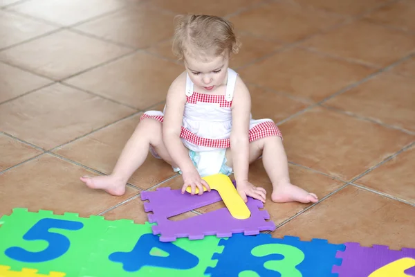 Ragazza che gioca con i numeri colorati puzzle — Foto Stock