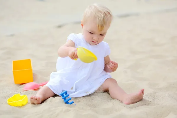 Bayi perempuan bermain dengan mainan pasir di pantai — Stok Foto