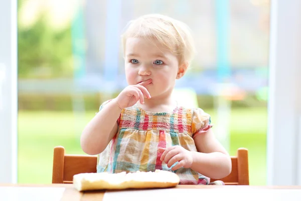 Flickan äta välsmakande bröd med smör — Stockfoto