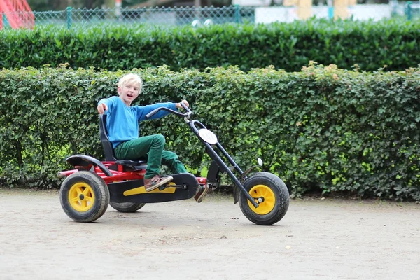 Junge fährt Fahrrad auf Spielplatz — Stockfoto