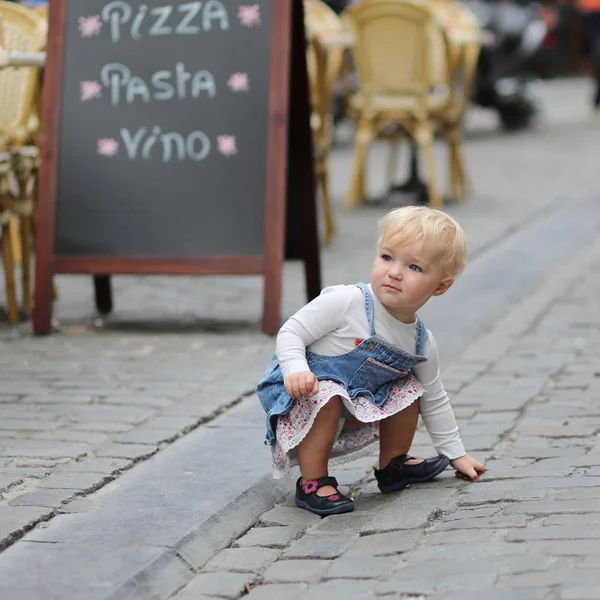 Baby flicka på en upptagen gata bredvid italienska café — Stockfoto