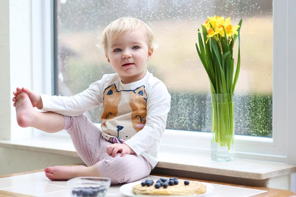 Girl enjoying pancakes sitting on the kitchen — Stock Photo, Image