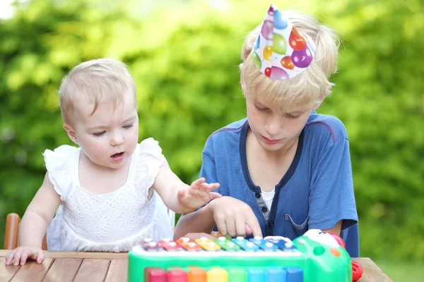 Niño jugando con su hermana en su primera fiesta de cumpleaños — Foto de Stock