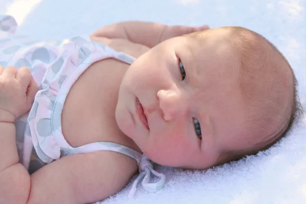 女婴在户外躺在白色的柔软的毛毯 — 图库照片