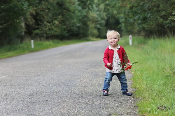 Baby girl walking on a road along autumn forest — Stock Photo, Image
