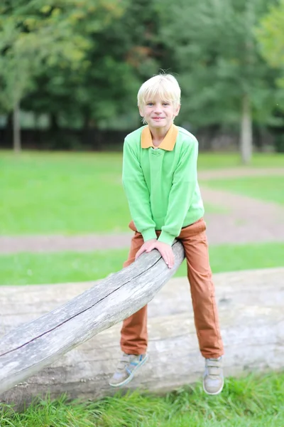 Jongen zittend op een tak van een boom — Stockfoto