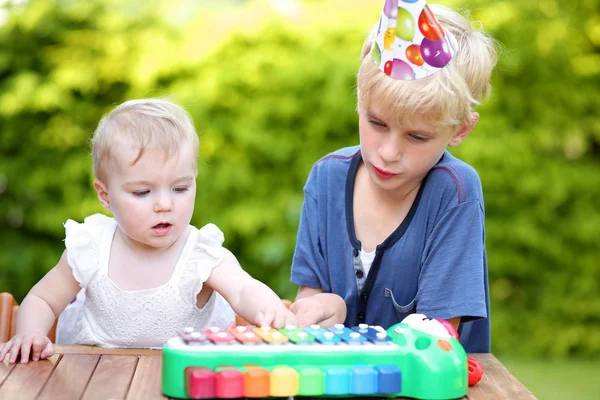 Ragazzo che gioca con la sua sorellina al suo primo compleanno — Foto Stock