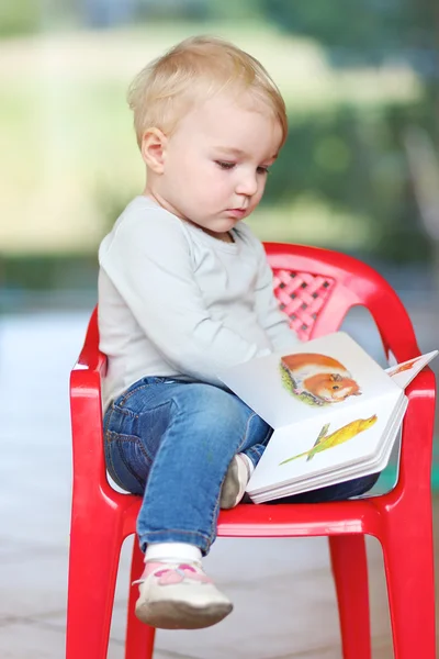 Baby girl reading children book about animals — Stock Photo, Image