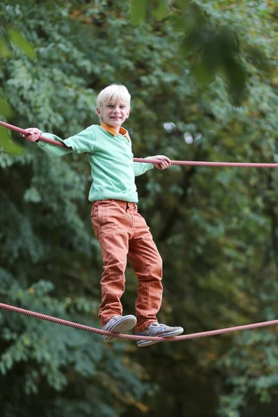 Ragazzo che si arrampica sulle corde al parco giochi — Foto Stock