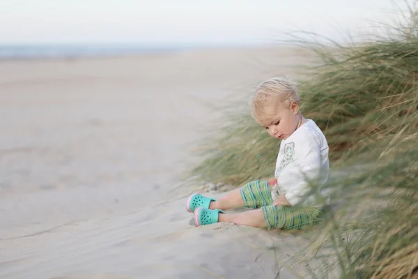Niña jugando en las dunas en la playa — Foto de Stock