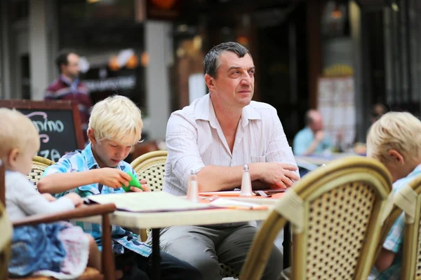 Pappa med tre barn har roligt i café — Stockfoto