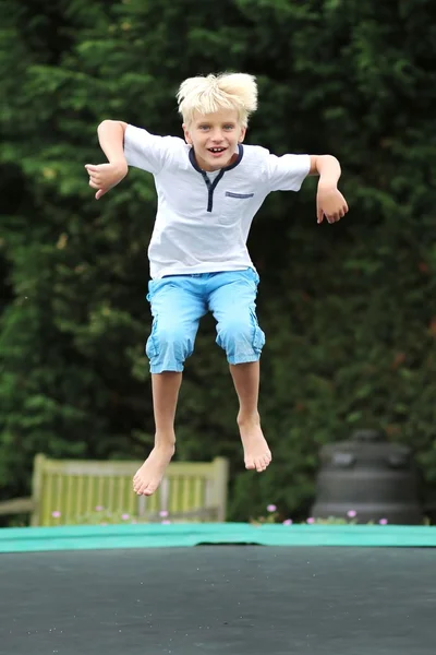 Rolig pojke hoppar på studsmatta — Stockfoto